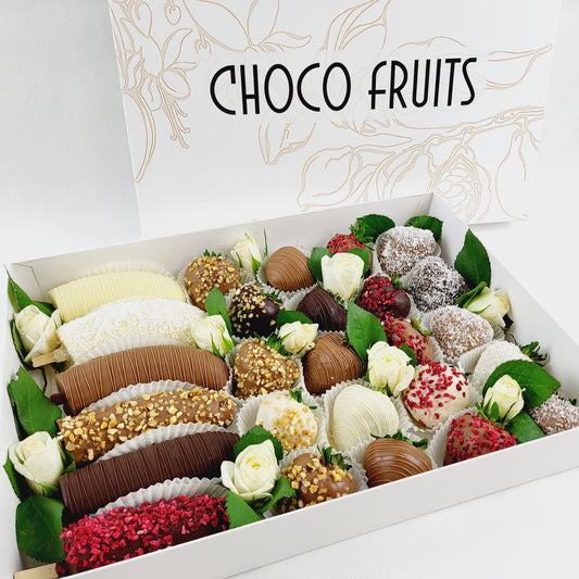 Choco Fruits Schokoerdbeeren und Schokobananen mit verschiedenen Topping und mit weißen Rosen dekoriert